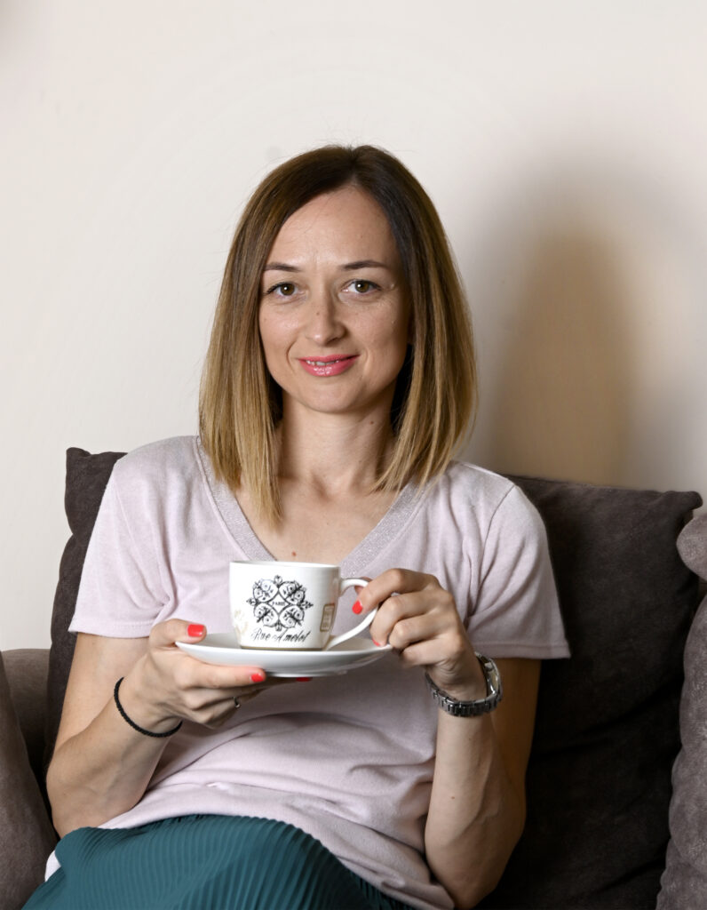Vinka je kouč za roditeljstvo. Ovde drži šoljicu kafe u rukama.