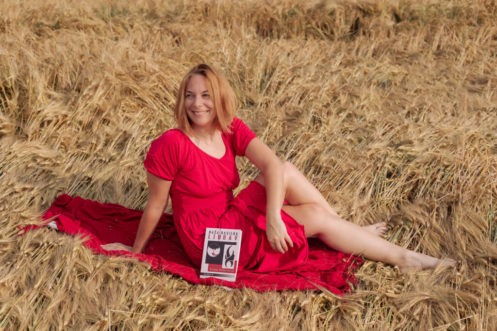 Bojana sedi srećna u polju žita jer je njena ideja zaživela u obliku romana NAŠA NASILNA LJUBAV
